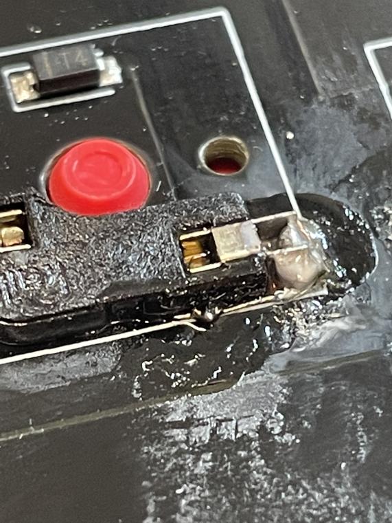 Kailh hot swap socket with a small wire connecting it to a via hole with a blob of solder